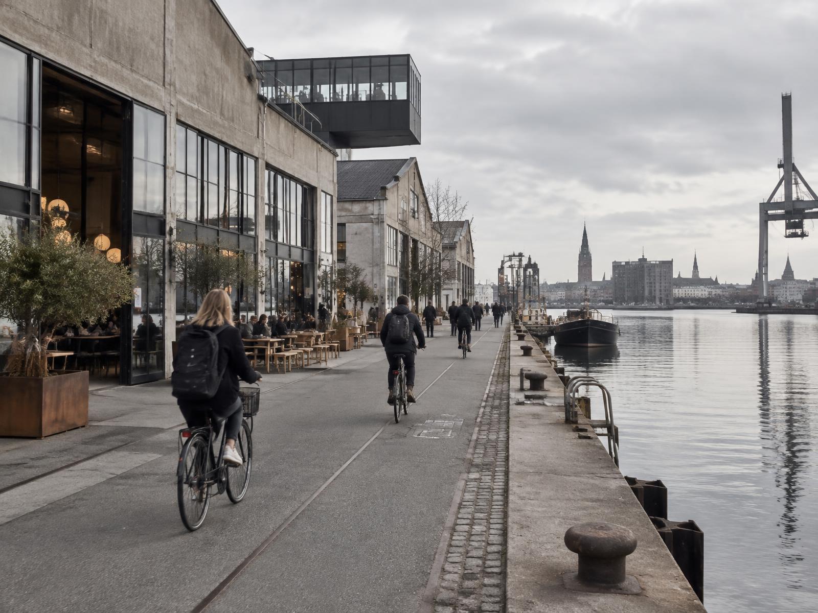 Cyclists and cafés along Copenhagen's industrial harbour
