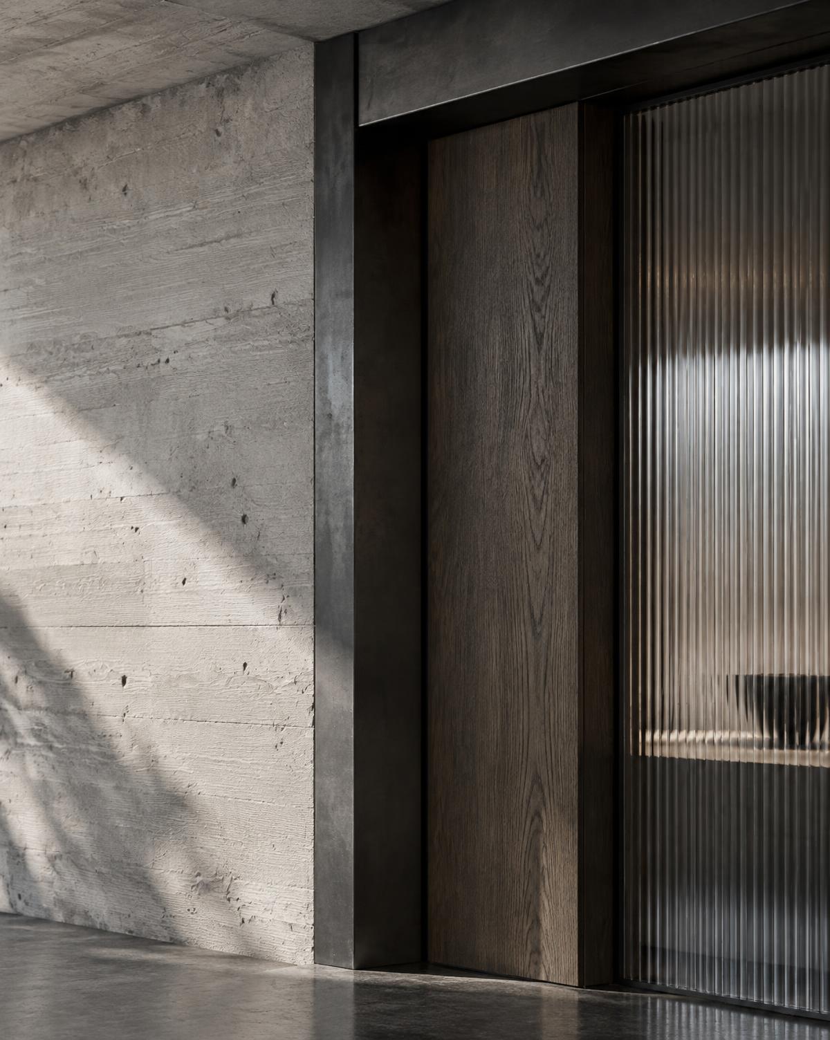 Board-marked concrete, blackened steel, smoked oak and ribbed glass